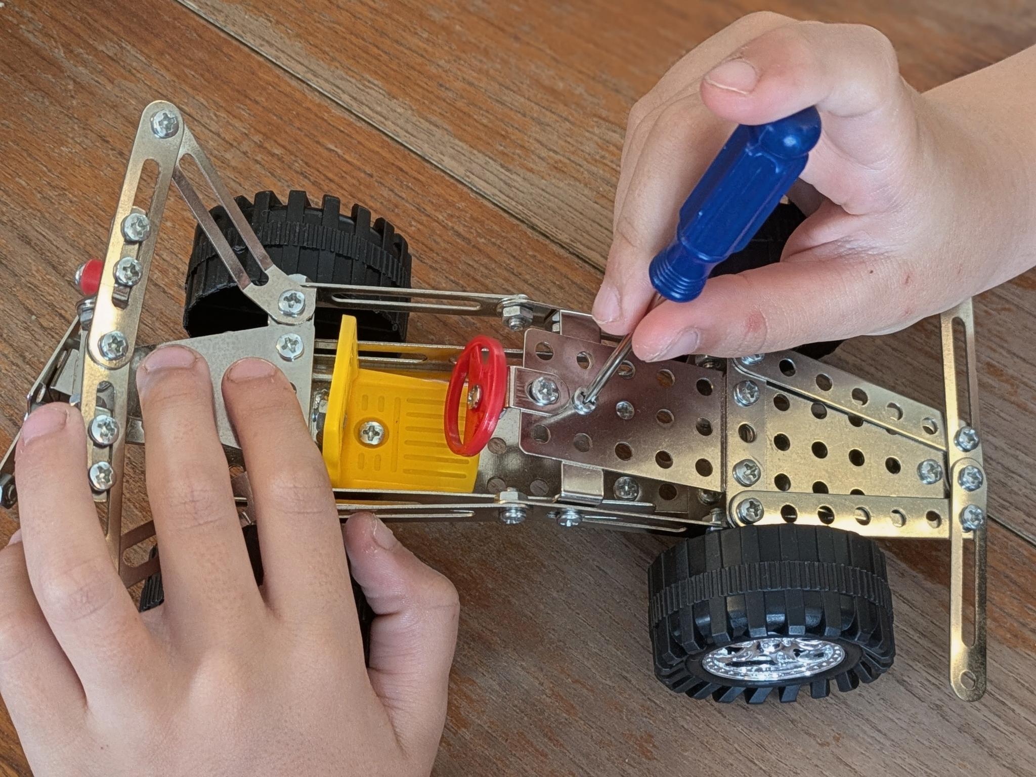 Child hands building with tools